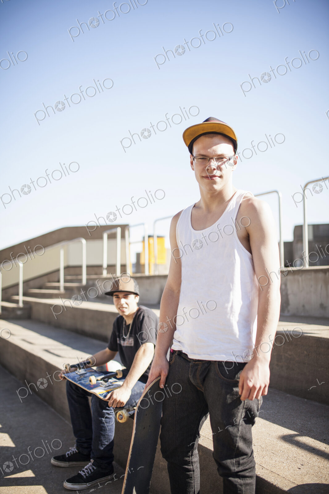 Caucasian men with skateboards sitting on steps