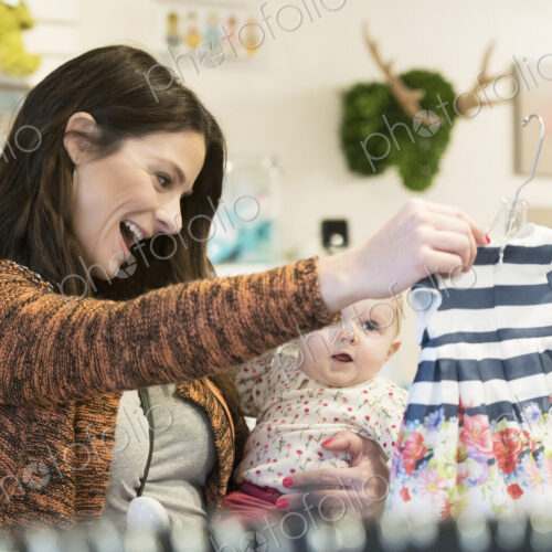 Caucasian mother and baby daughter shopping in clothing store Caucasian mother and baby daughter shopping in clothing store
