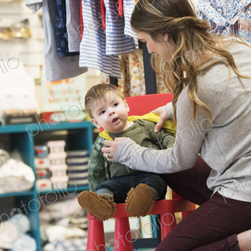 Caucasian mother and baby son shopping in clothing store Caucasian mother and baby son shopping in clothing store