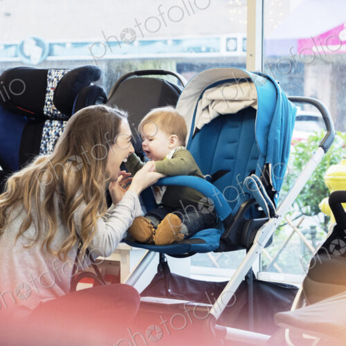 Caucasian mother and baby son shopping in stroller store Caucasian mother and baby son shopping in stroller store