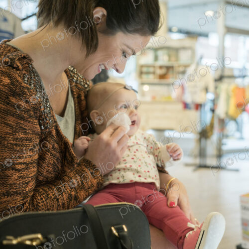 Caucasian mother wiping cheek of baby daughter Caucasian mother wiping cheek of baby daughter