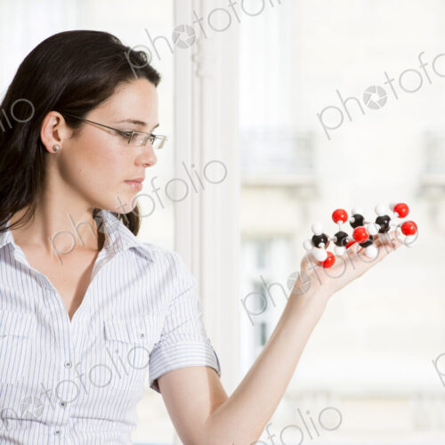 Caucasian scientist examining molecular model Caucasian scientist examining molecular model