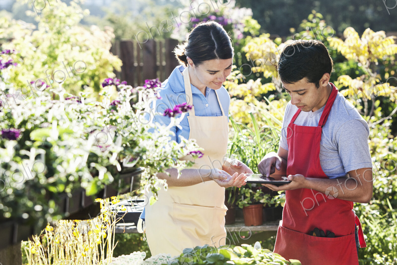 Caucasian woman and man employees of garden center nursery checking out an order on a…