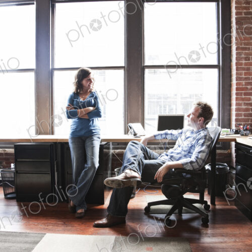 Caucasian woman and man meeting to discuss an issue at a creative office workstation.