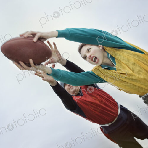 Caucasian woman being tackled and diving with arms outstretched to score, holding a… Caucasian woman being tackled and diving with arms outstretched to score, holding a…