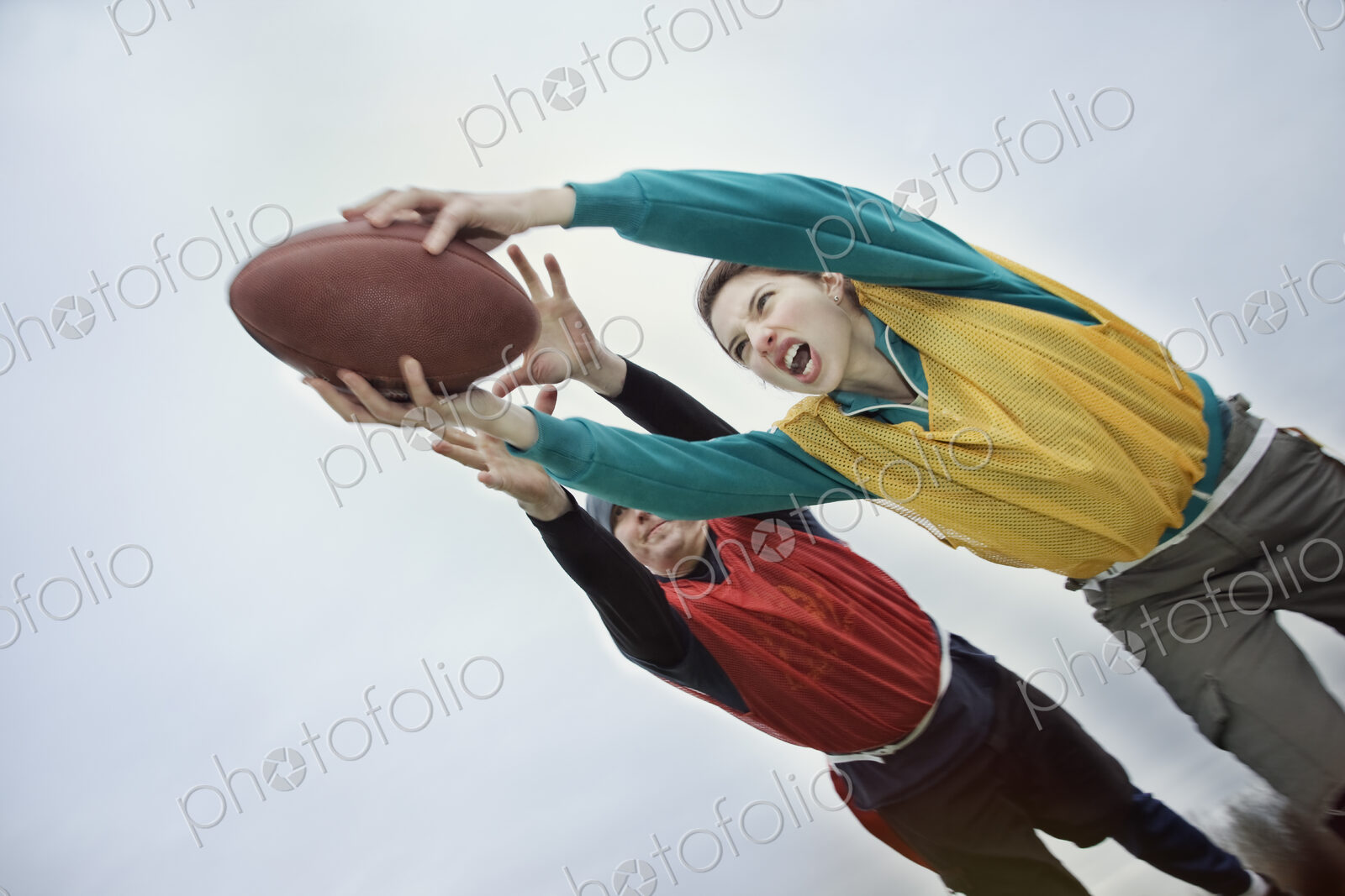Caucasian woman being tackled and diving with arms outstretched to score, holding a…
