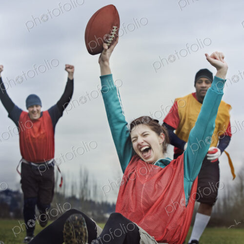 Caucasian woman celebrating with arms raised, scoring points in the end zone, in a… Caucasian woman celebrating with arms raised, scoring points in the end zone, in a…