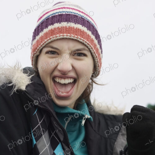 Caucasian woman cheering at an informal sporting event in the winter. Caucasian woman cheering at an informal sporting event in the winter.