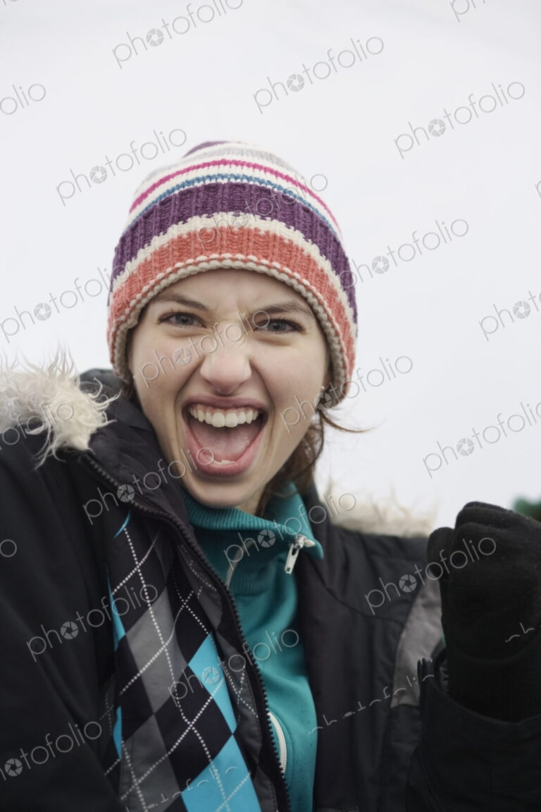 Caucasian woman cheering at an informal sporting event in the winter.