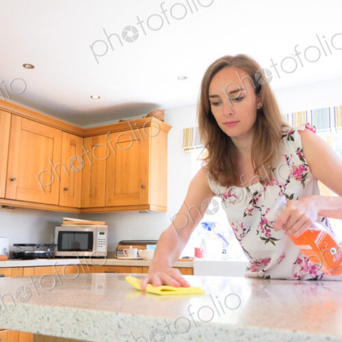 Caucasian woman cleaning kitchen counter Caucasian woman cleaning kitchen counter
