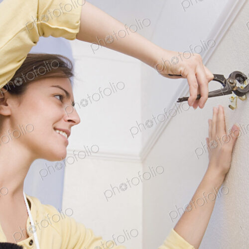 Caucasian woman doing home repair Caucasian woman doing home repair