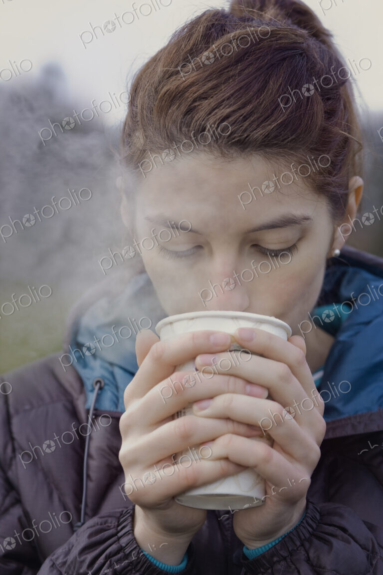 Caucasian woman drinking a hot cup of coffee on a winter day.