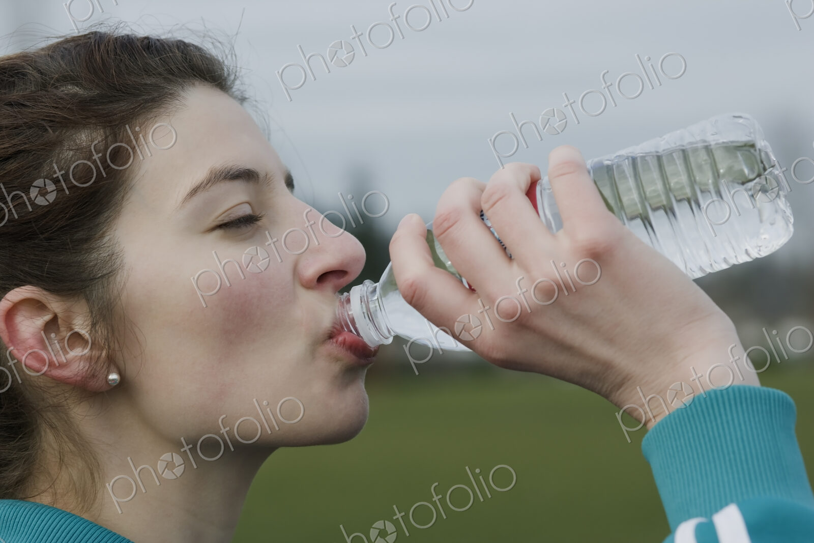Caucasian woman drinking water from a bottle.