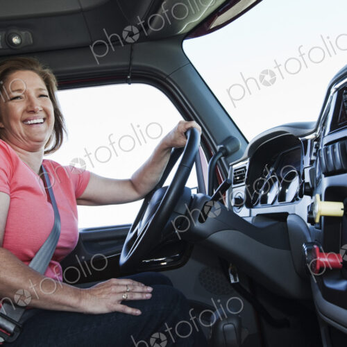 Caucasian woman driver in the cab of a commercial truck. Caucasian woman driver in the cab of a commercial truck.