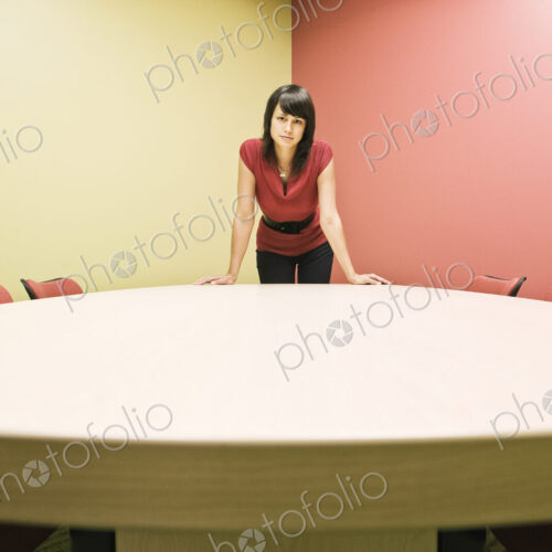 Caucasian woman in a conference room standing leaning on a table, confident pose. Caucasian woman in a conference room standing leaning on a table, confident pose.