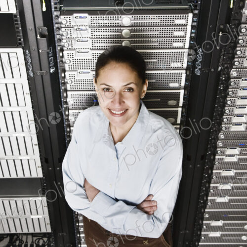 Caucasian woman lab technician working on servers in a computer sever farm. Caucasian woman lab technician working on servers in a computer sever farm.