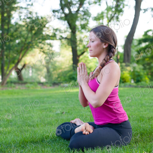 Caucasian woman meditating in park Caucasian woman meditating in park