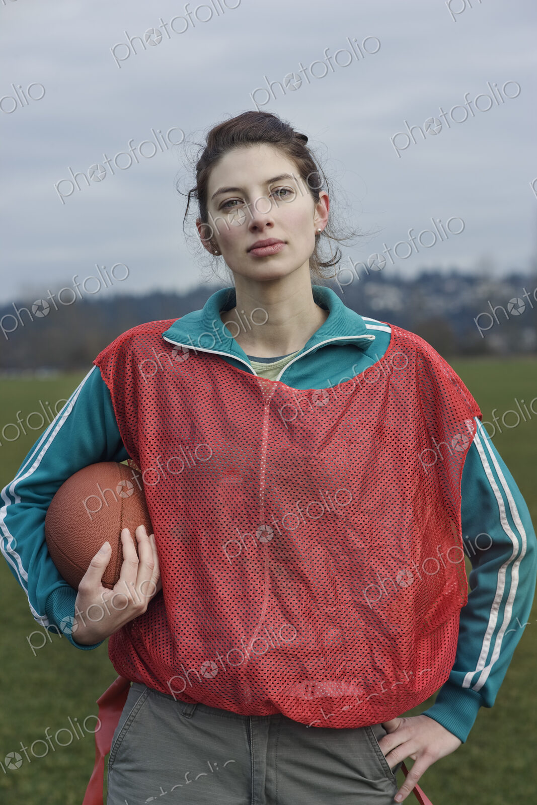 Caucasian woman member of a non-contact flag football team holding a football.