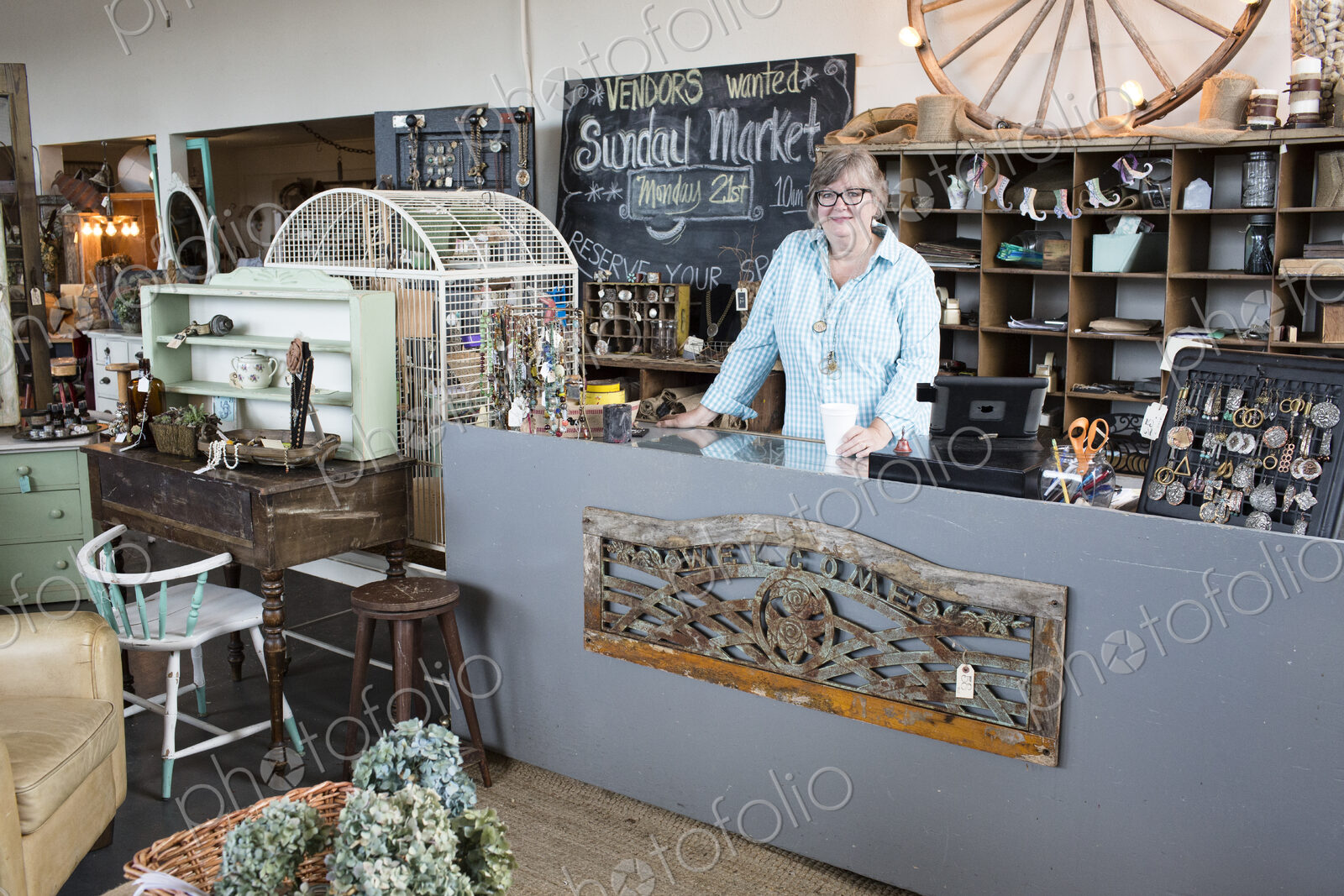 Caucasian woman owner of an antique store standing near the cash register