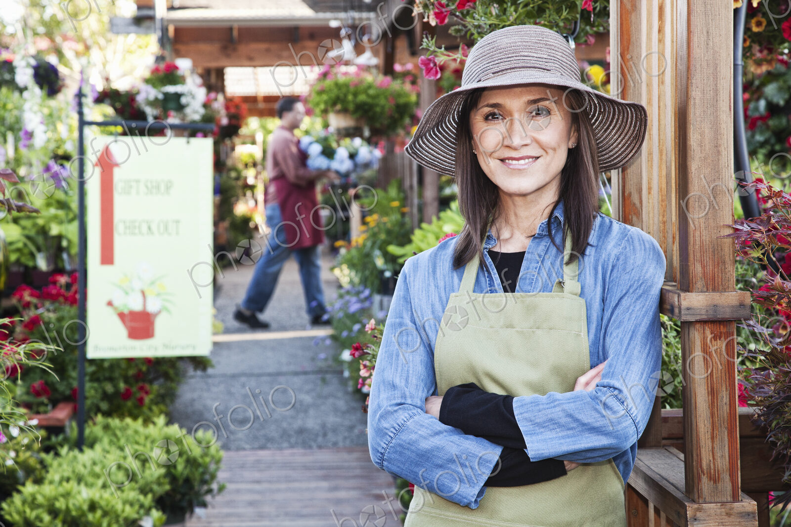 Caucasian woman owner of garden center nursery with a younger employee.
