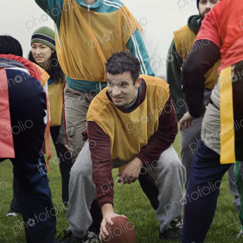 Caucasian woman playing quarterback for a team of friends playing non-contact flag…