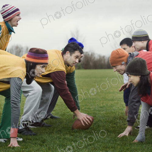 Caucasian woman playing quarterback for a team of friends playing non-contact flag… Caucasian woman playing quarterback for a team of friends playing non-contact flag…
