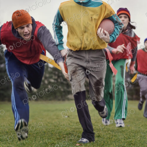 Caucasian woman running with the football in an non-contact flag football game. Caucasian woman running with the football in an non-contact flag football game.