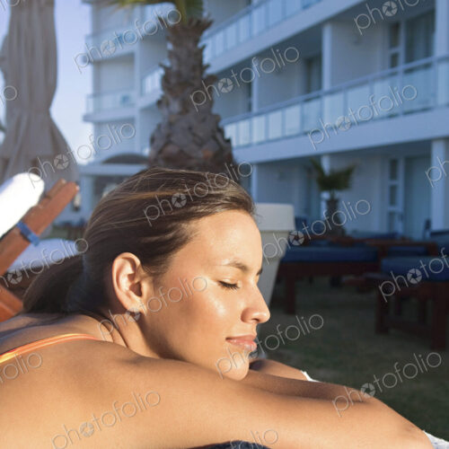 Caucasian woman sunbathing in lawn chair