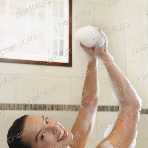 Caucasian woman taking bubble bath in bathroom