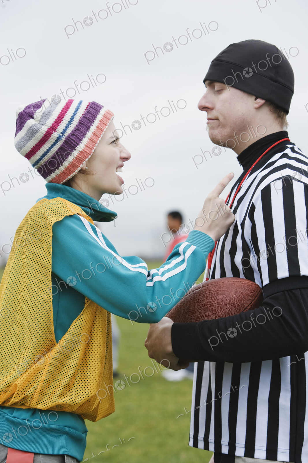 Caucasian woman team member arguig wtih a referee while playing non-contact flag football.
