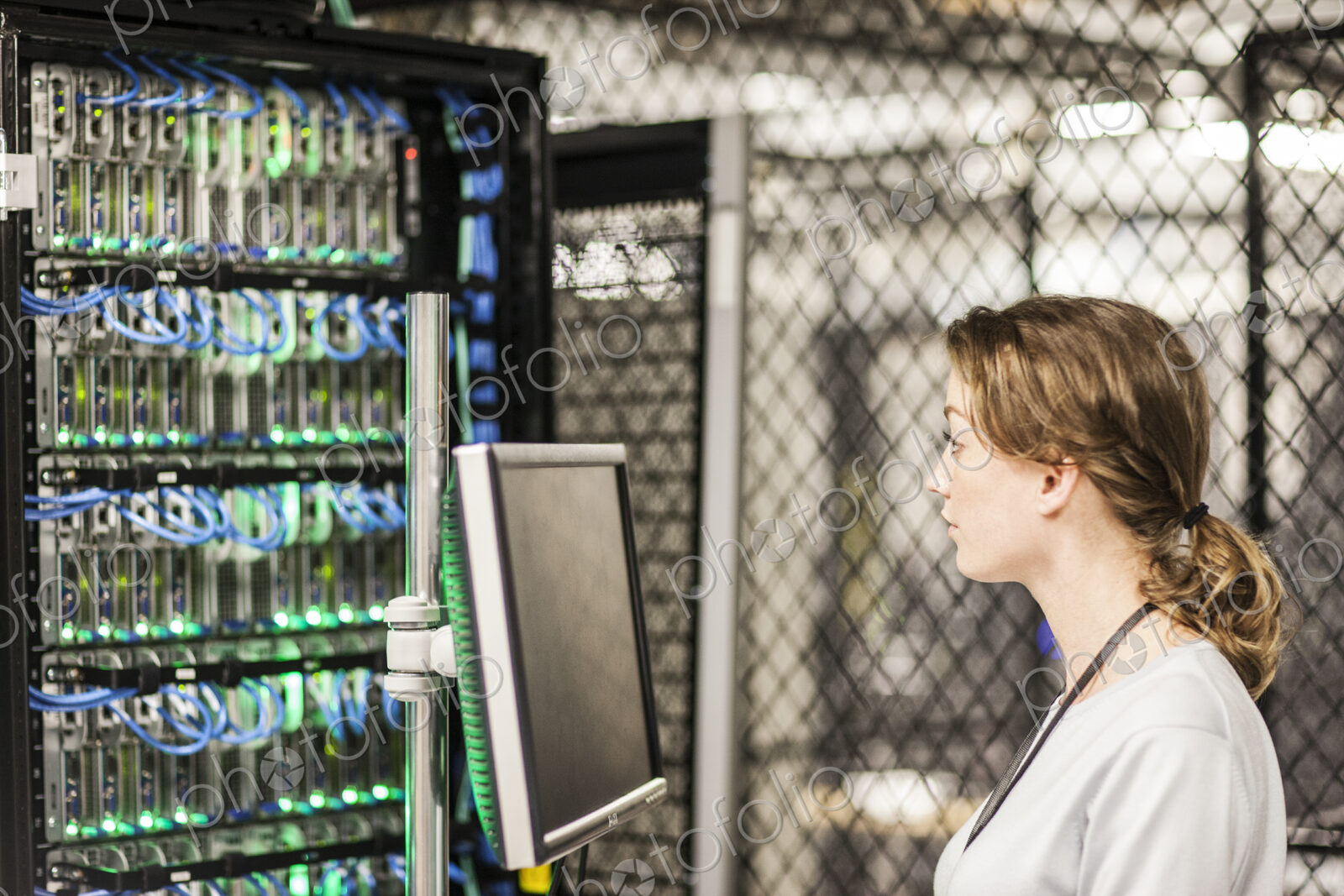 Caucasian woman technician doing diagnostic tests on computer servers in a server farm.