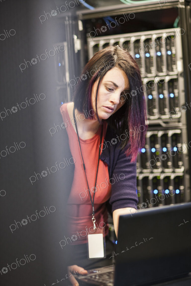 Caucasian woman technician in a large computer server farm.