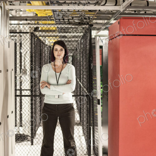Caucasian woman technician in a large computer server farm. Caucasian woman technician in a large computer server farm.