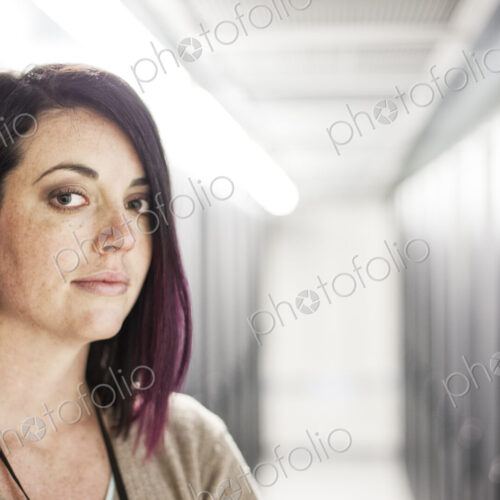 Caucasian woman technician in a large computer server farm.