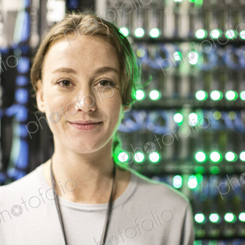 Caucasian woman technician in a large computer server farm. Caucasian woman technician in a large computer server farm.