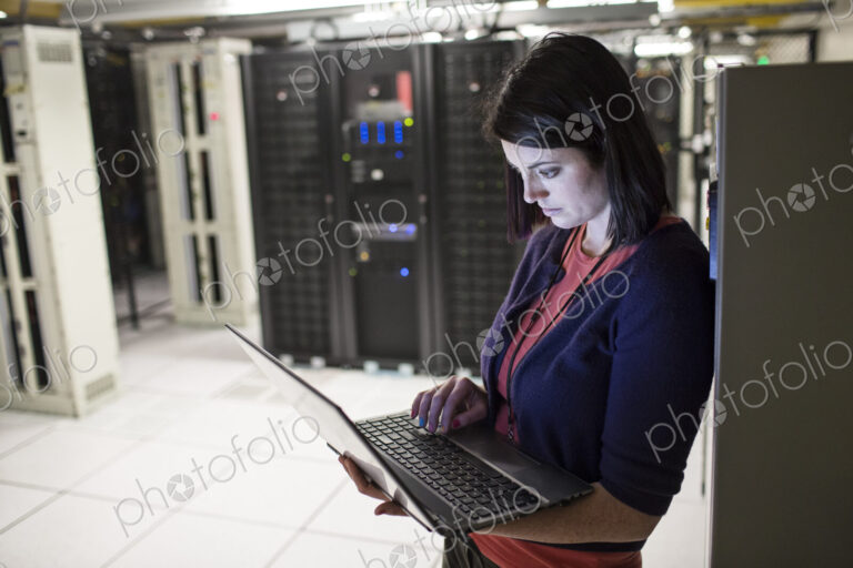Caucasian woman technician in a large computer server farm.