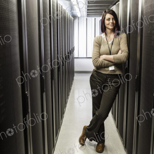 Caucasian woman technician in a large computer server farm. Caucasian woman technician in a large computer server farm.
