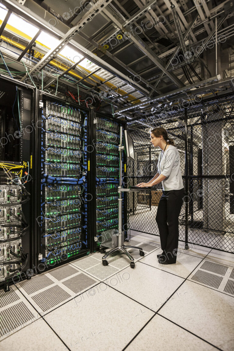 Caucasian woman technician working on computer servers in a server farm.