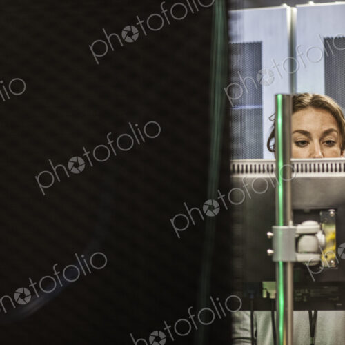 Caucasian woman technician working on computer servers in a server farm.