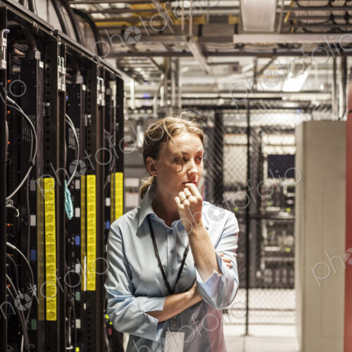Caucasian woman technician working on computer servers in a server farm. Caucasian woman technician working on computer servers in a server farm.