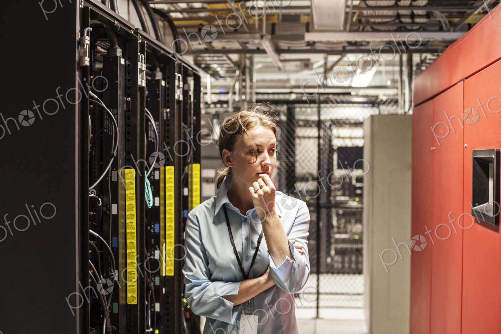 Caucasian woman technician working on computer servers in a server farm.