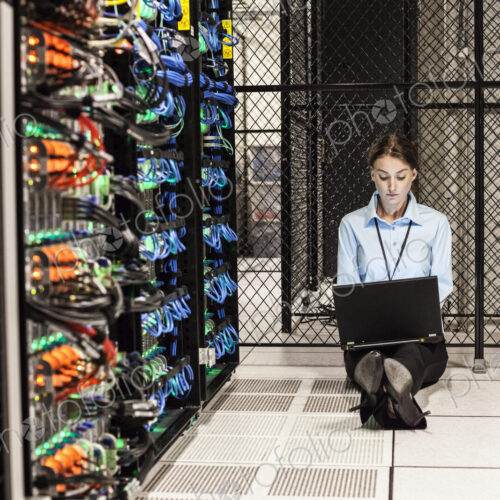 Caucasian woman technician working on computer servers in a server farm. Caucasian woman technician working on computer servers in a server farm.
