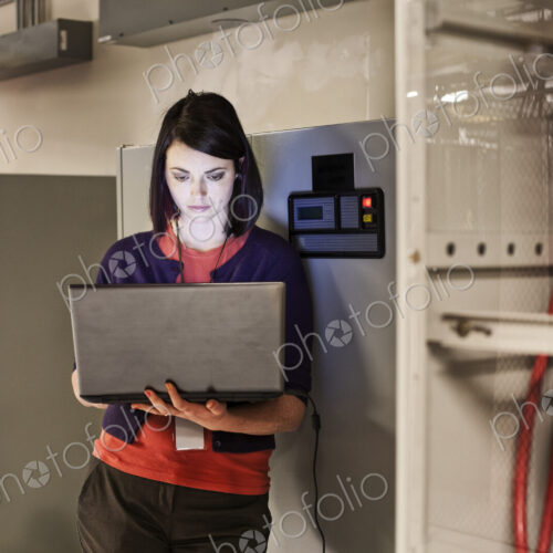 Caucasian woman technician working on computer servers in a server farm. Caucasian woman technician working on computer servers in a server farm.