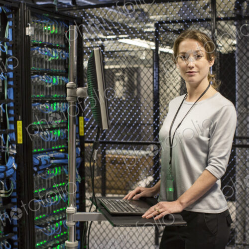 Caucasian woman technician working on computer servers in a server farm. Caucasian woman technician working on computer servers in a server farm.