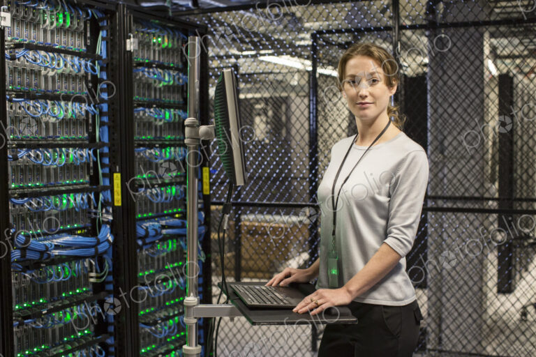 Caucasian woman technician working on computer servers in a server farm.