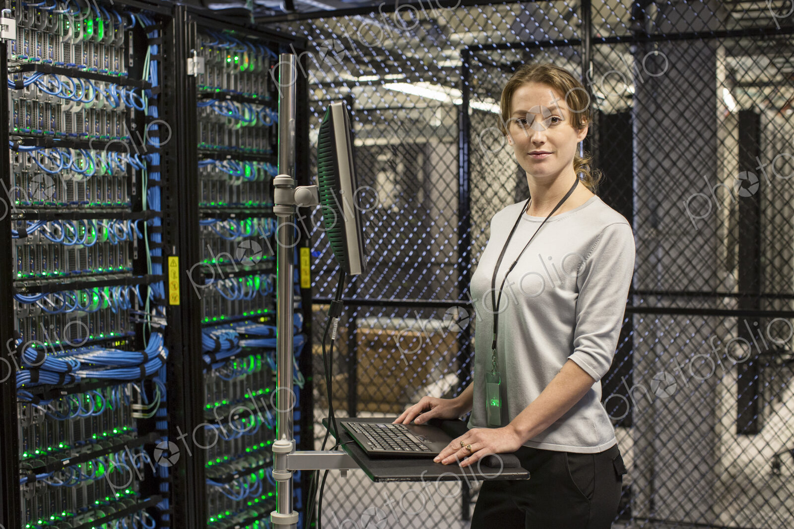 Caucasian woman technician working on computer servers in a server farm.
