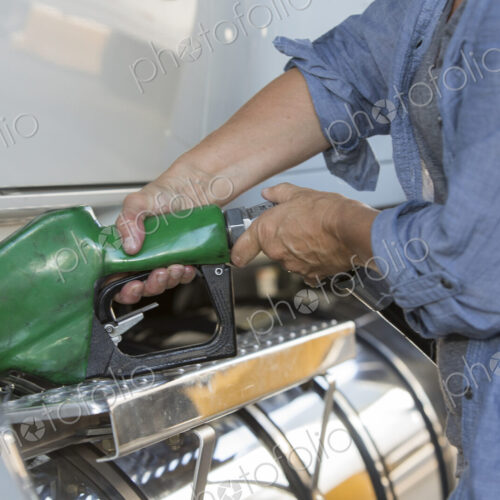 Caucasian woman truck driver filling truck with diesel fuel at a truck stop. Caucasian woman truck driver filling truck with diesel fuel at a truck stop.
