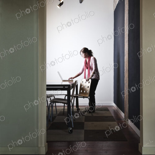 Caucasian woman working on a laptop computer in a small conference room. Caucasian woman working on a laptop computer in a small conference room.