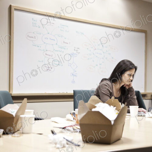 Caucasian woman working through lunch at a conference room table. Caucasian woman working through lunch at a conference room table.