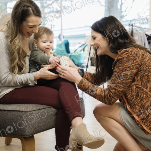 Caucasian women and baby boy shopping in shoe store Caucasian women and baby boy shopping in shoe store